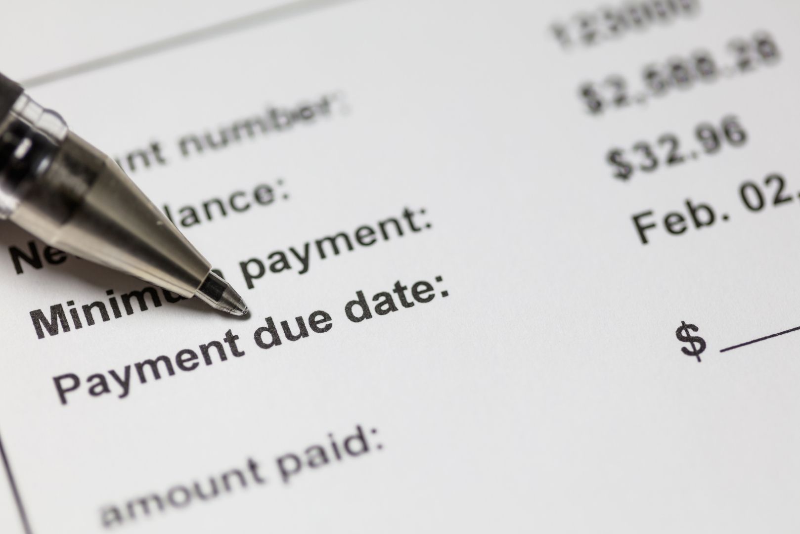 A close-up shot of a bill with a pen pointing to the "Payment due date" line.